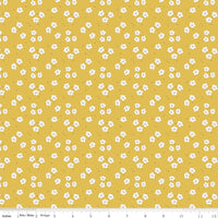 Yellow fabric with small white floral pattern and ruler for scale