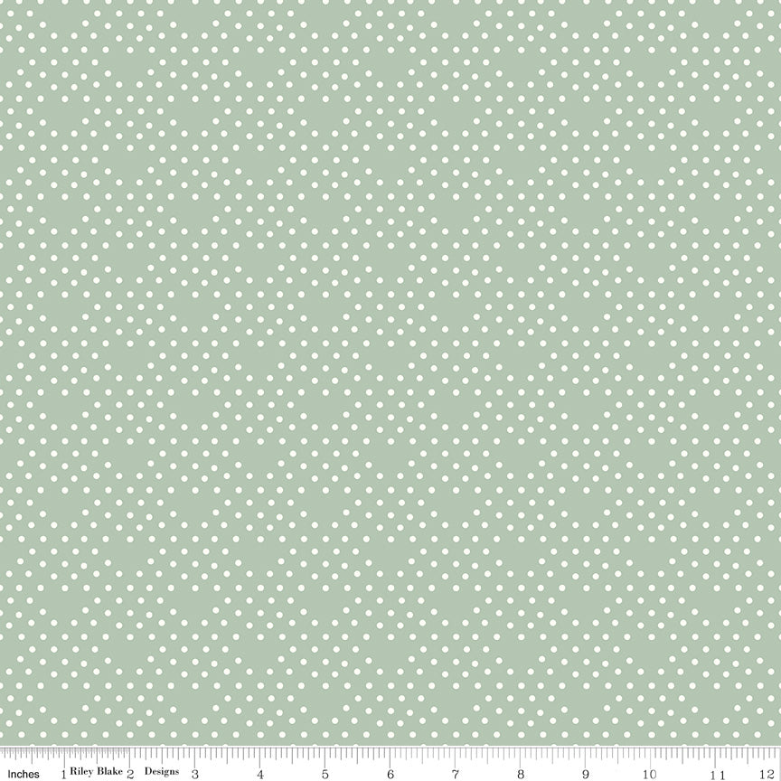 Fabric with small white polka dots on a light green background