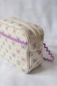 Small cosmetic bag with butterfly pattern and purple baby ric rac on a white background