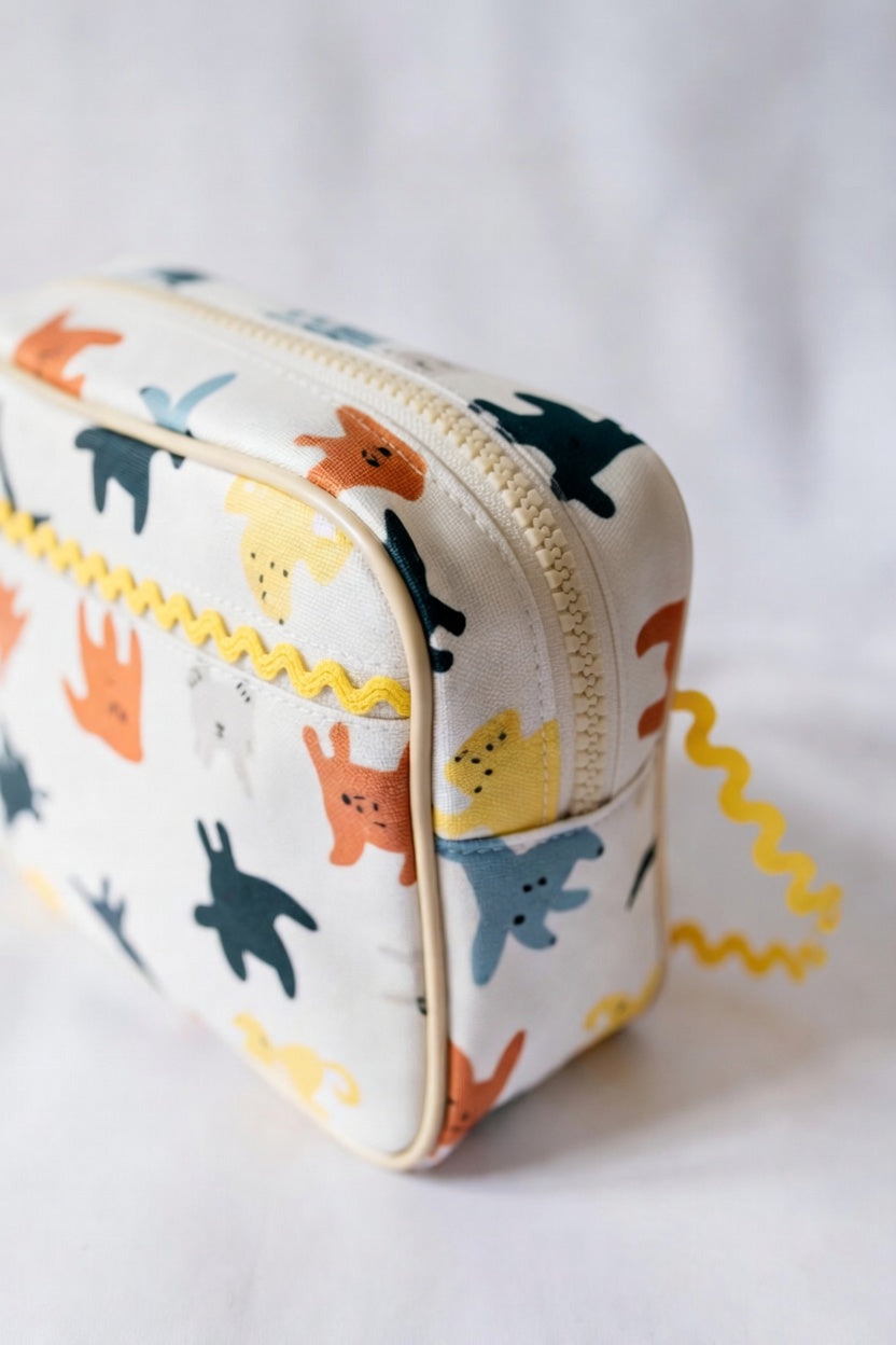 Small pouch with animal pattern and yellow baby ric rac on a white background