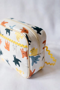 Small pouch with animal pattern and yellow baby ric rac on a white background